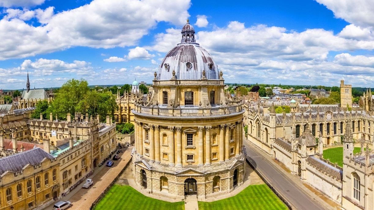 Radcliffe Camera at Oxford University, England, surrounded by historic buildings and green lawns.