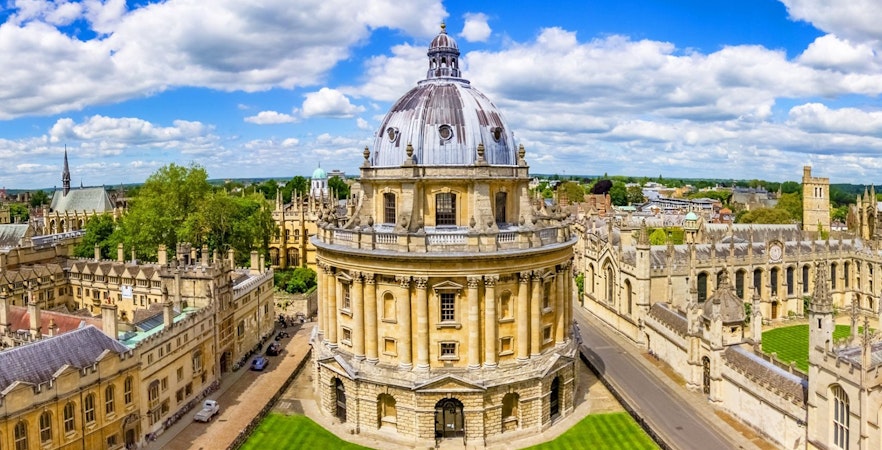 Radcliffe Camera at Oxford University, England, surrounded by historic buildings and green lawns.