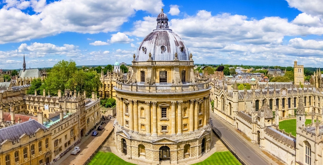 Radcliffe Camera at Oxford University, England, surrounded by historic buildings and green lawns.