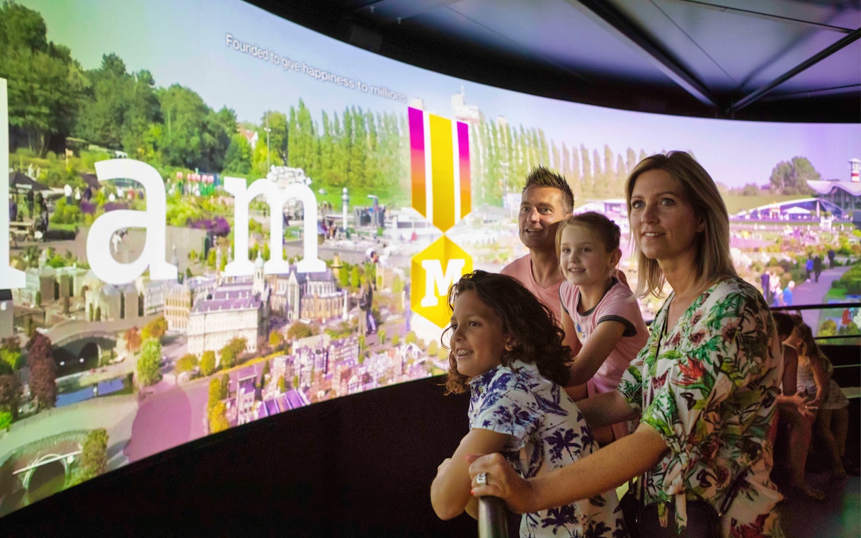 Family viewing miniature city display at Madurodam Miniature Park.