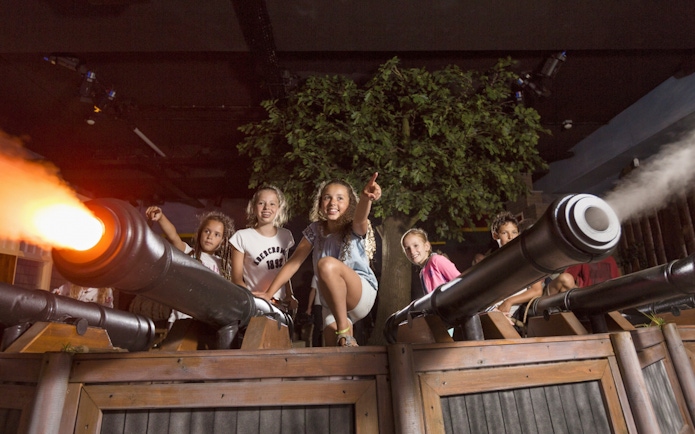 Children interacting with cannons at Madurodam Miniature Park.