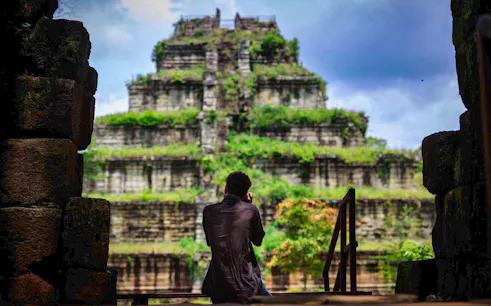 Person photographing the ancient Koh Ker temple in Cambodia.