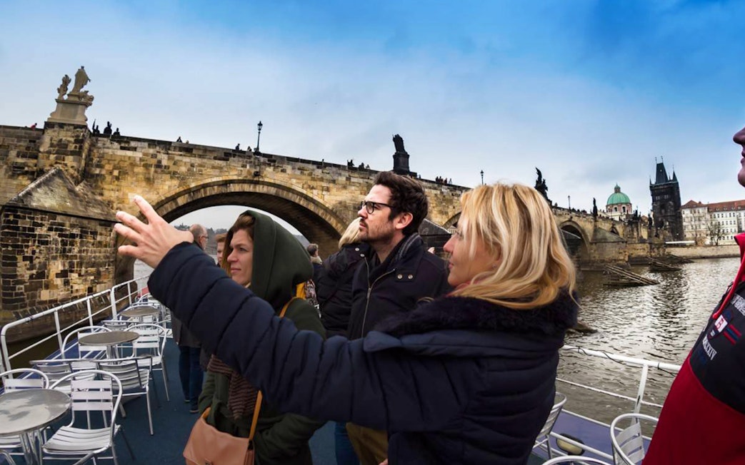Tourists on a boat cruise near Charles Bridge in Prague.