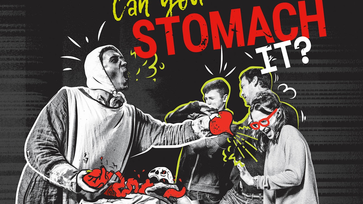 Actors in medieval costumes performing at Amsterdam Dungeon attraction.