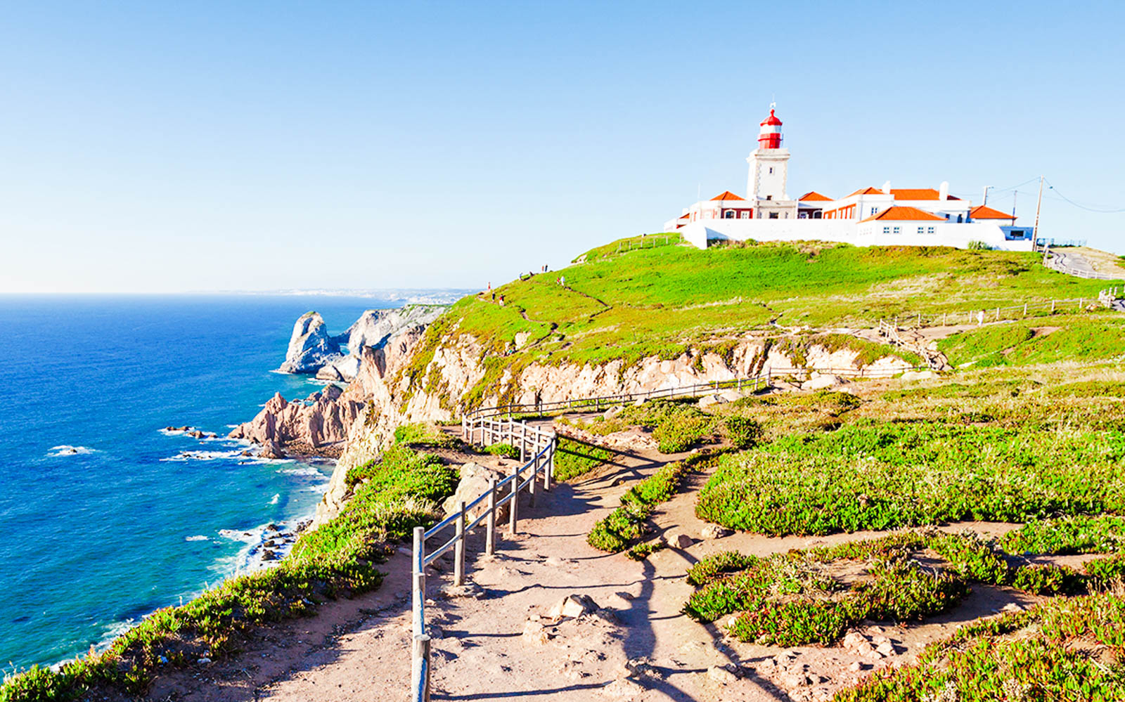 Cabo da Roca lighthouse on a cliff overlooking the Atlantic Ocean, part of a Lisbon day tour.