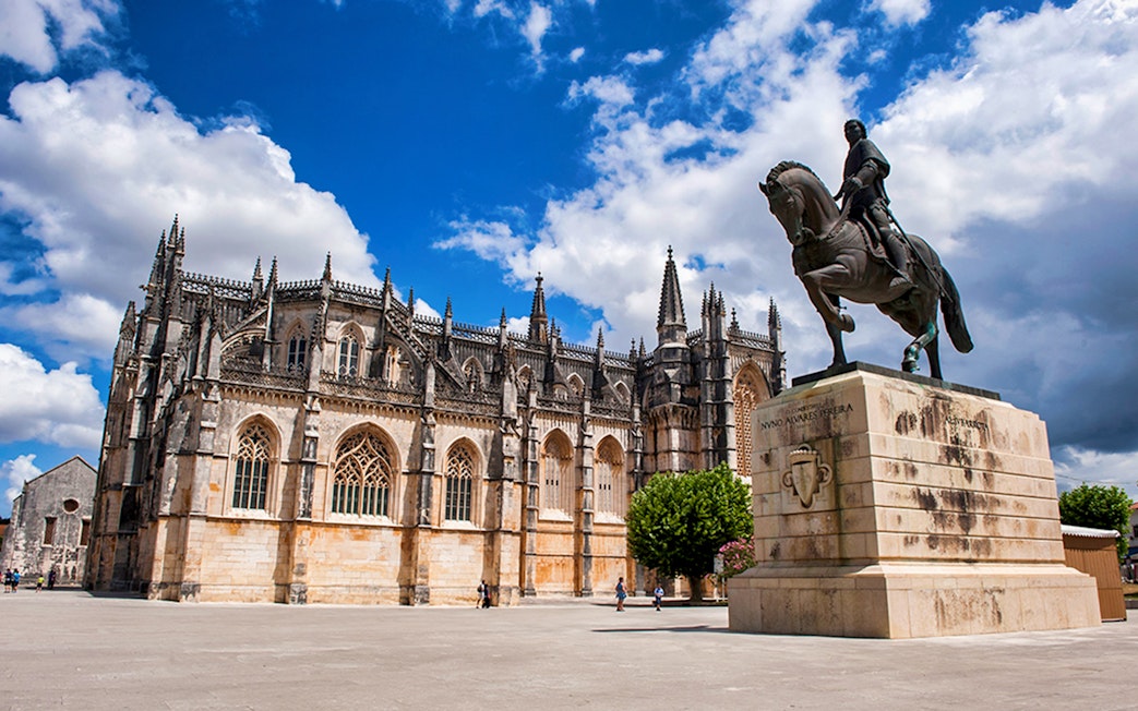 Batalha Monastery and equestrian statue in Batalha, Portugal, on a sunny day.