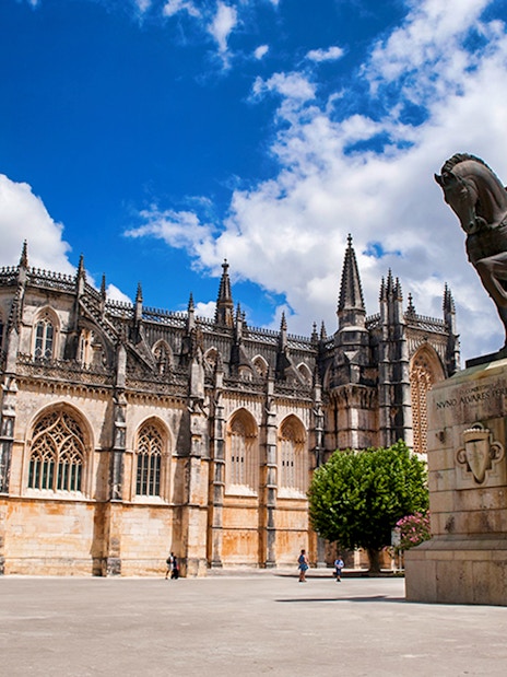 Batalha Monastery and equestrian statue in Batalha, Portugal, on a sunny day.