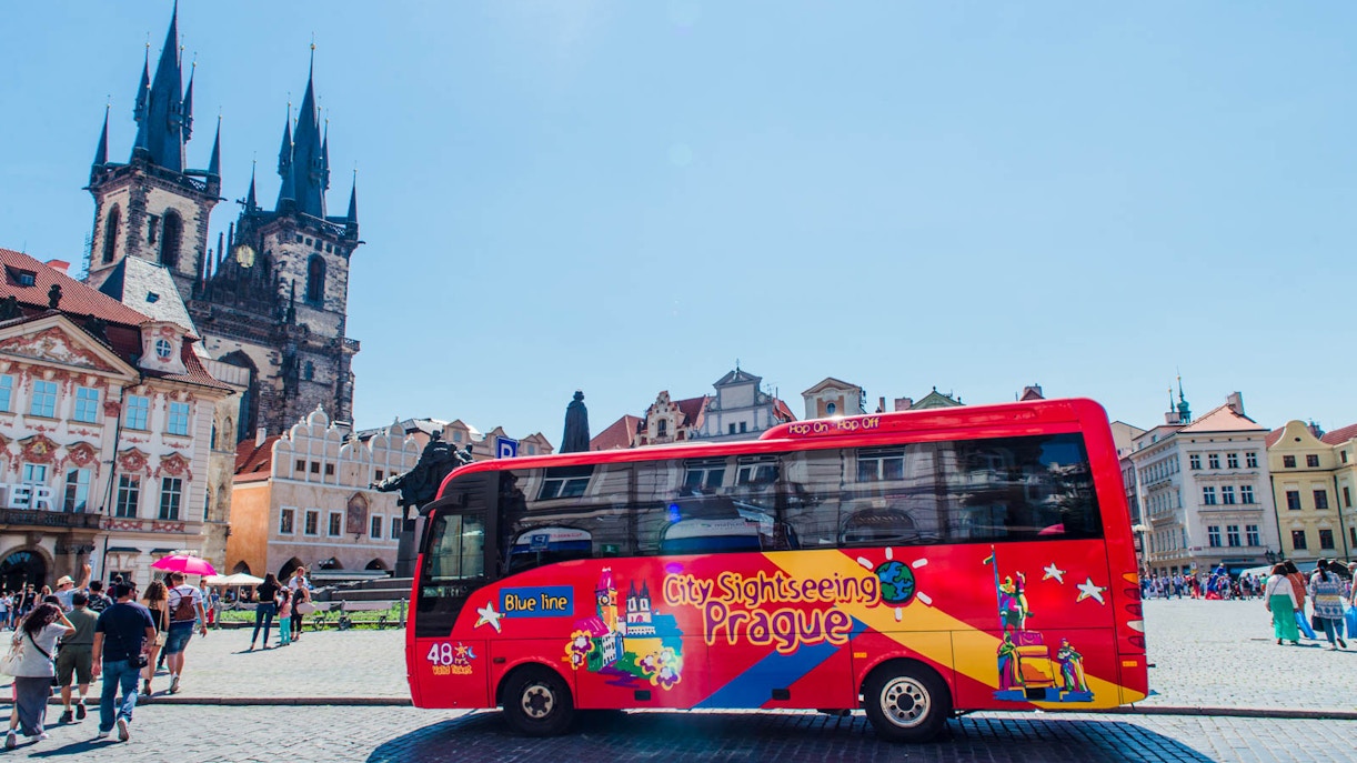 Prague hop-on hop-off bus tour passing by historic city landmarks.