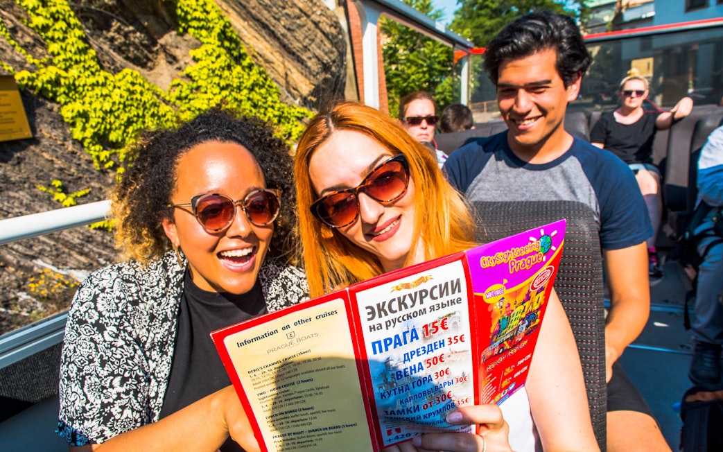 Tourists enjoying a City Sightseeing Prague Hop-On Hop-Off bus tour.
