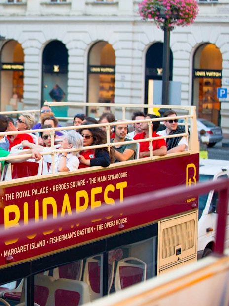 Open-top bus with tourists on a Hop-On Hop-Off tour in Budapest.