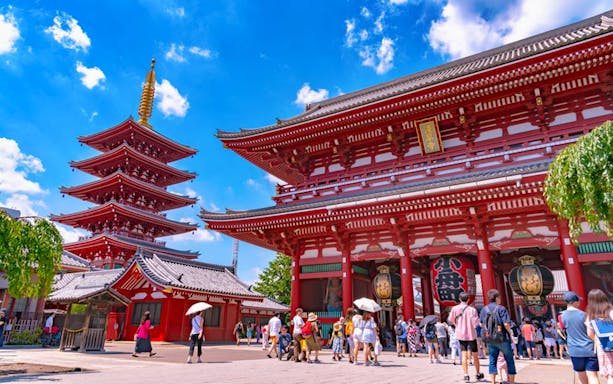 Senso-ji Temple in Tokyo with visitors exploring the historic site on a sunny morning.