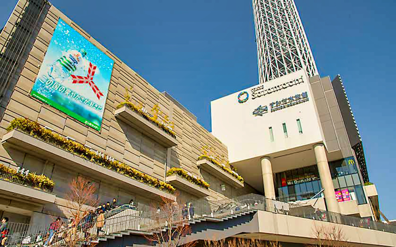 Tokyo Skytree with surrounding shopping complex on a sunny afternoon.