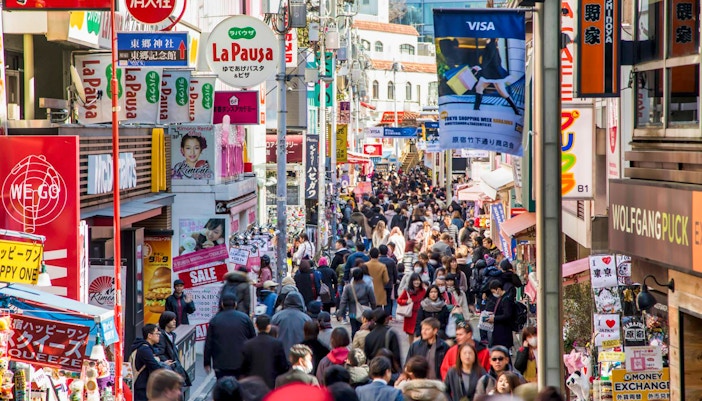 Harajuku street scene with people enjoying crepes, Tokyo walking tour.