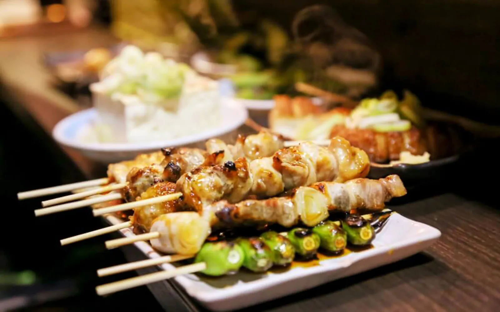Grilled skewers on a plate during Shinjuku Omoide Yokocho food tour.