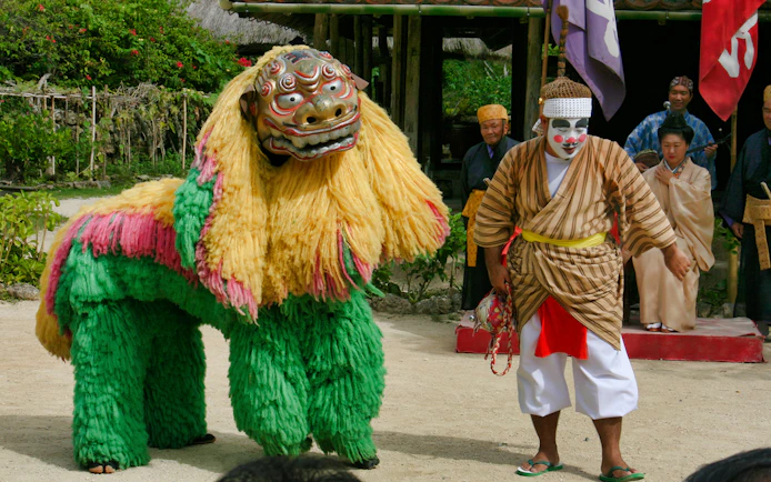 Traditional performance with lion dance and performers at Okinawa Ryukyu Mura Village.