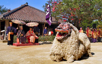 Traditional Ryukyu dance performance at Okinawa Ryukyu Mura Village with performers in cultural attire.