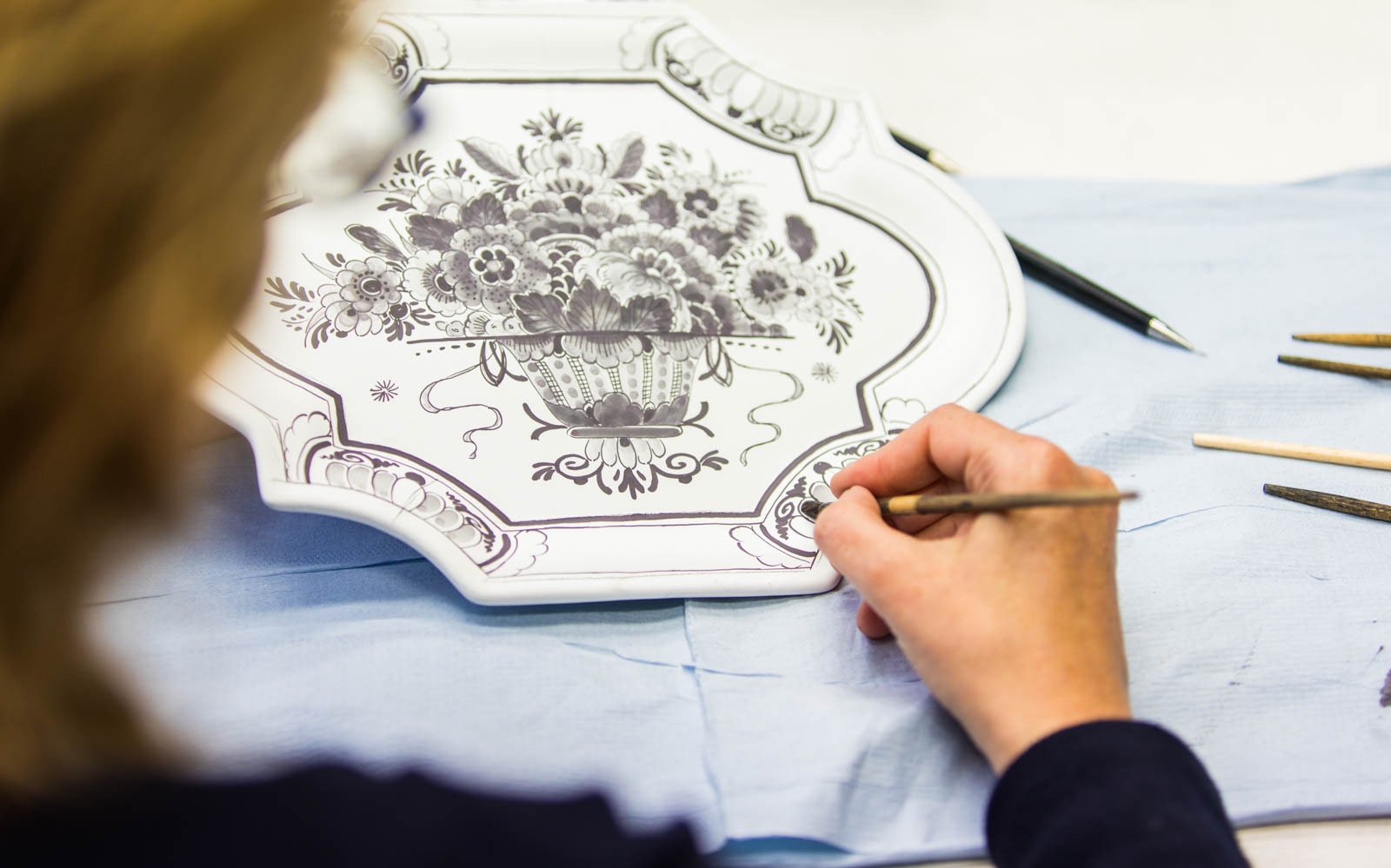 Crafting Delft pottery design during Delft, The Hague & Madurodam tour.