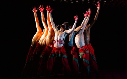 Dancers from Akram Khan Company performing "We are but Shadows" with raised arms.