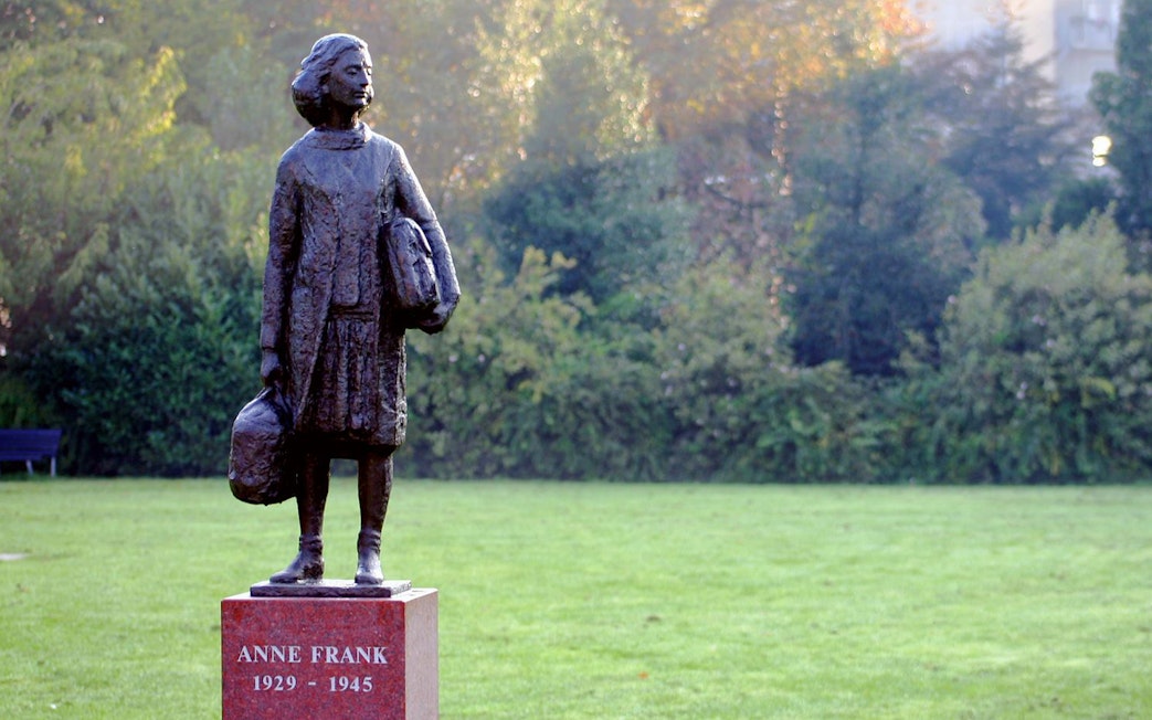 Anne Frank statue in a park setting, Amsterdam.
