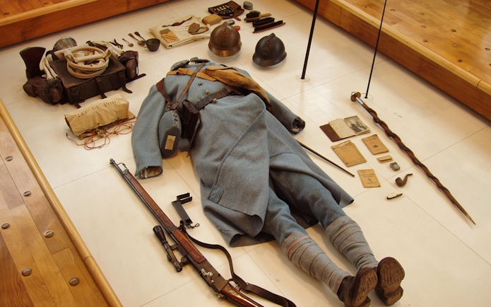 World War II soldier's uniform and equipment display at Normandy museum.