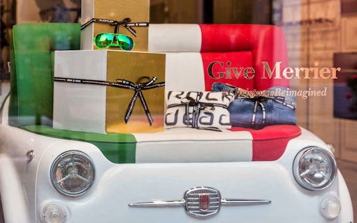 Serravalle Designer Outlet display with Italian-themed gifts and Fiat car seat.
