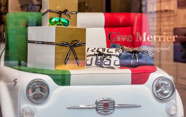 Serravalle Designer Outlet display with Italian-themed gifts and Fiat car seat.