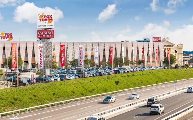 FoxTown Designer Outlet with parking and highway view, featuring Casino Admiral, near Milan.