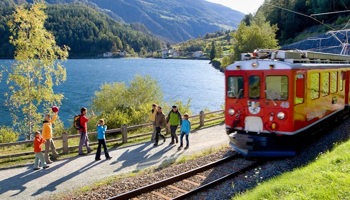 Bernina Express traversing Swiss Alps near St. Moritz with panoramic mountain views.