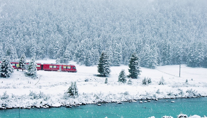 Bernina Express train crossing Alps with scenic views on full-day St. Moritz tour from Milan.