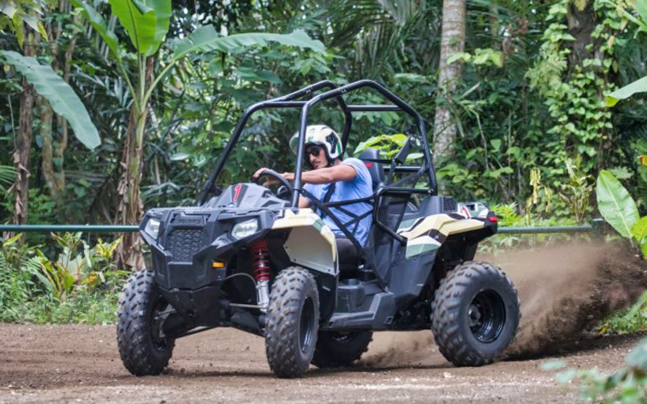 ATV driving through lush jungle trail on Jungle Buggies tour.