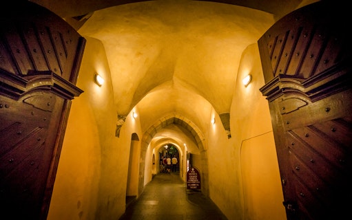 Dimly lit arched hallway in Prague's Old Town, part of the evening ghost tour.