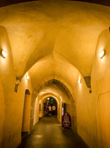 Dimly lit arched hallway in Prague's Old Town, part of the evening ghost tour.