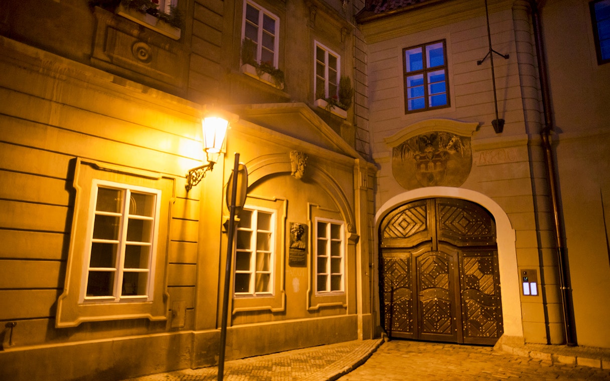 Historic Prague street at night with illuminated old town architecture.