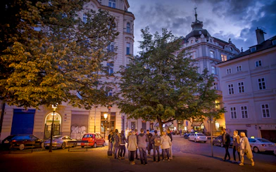 Group gathered under streetlights in Prague's Old Town for an evening ghost tour.