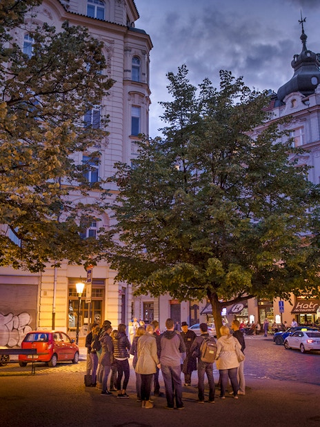 Group gathered under streetlights in Prague's Old Town for an evening ghost tour.