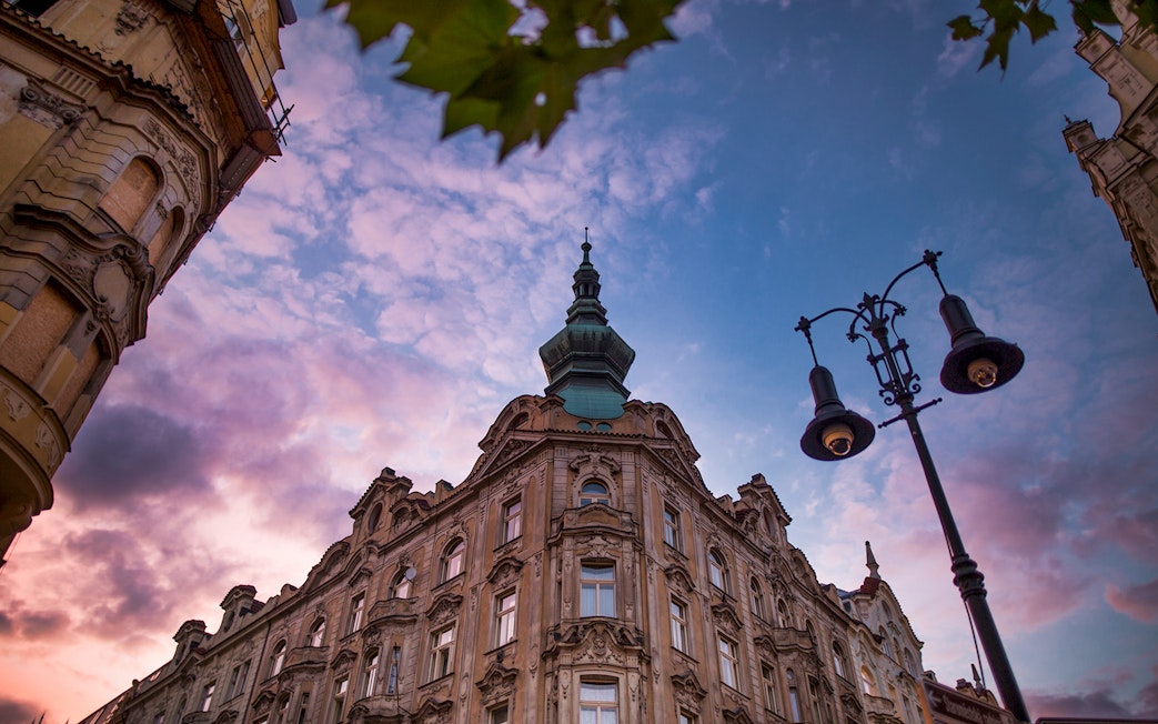 Historic building and street lamp at sunset in Prague's Old Town.