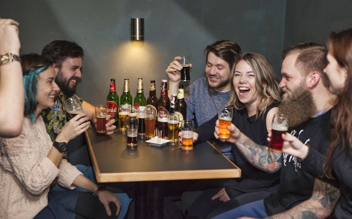Group enjoying Czech beer tasting with traditional snacks in Prague pub.