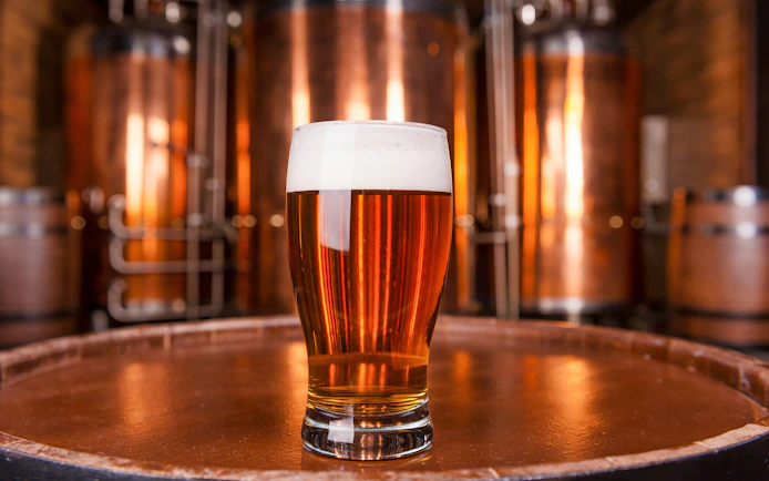 Glass of beer on a barrel in a Prague brewery.