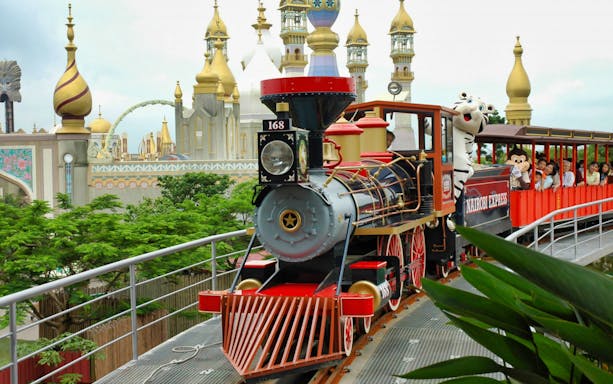 Train ride at Leofoo Village Theme Park with passengers and themed architecture in the background.
