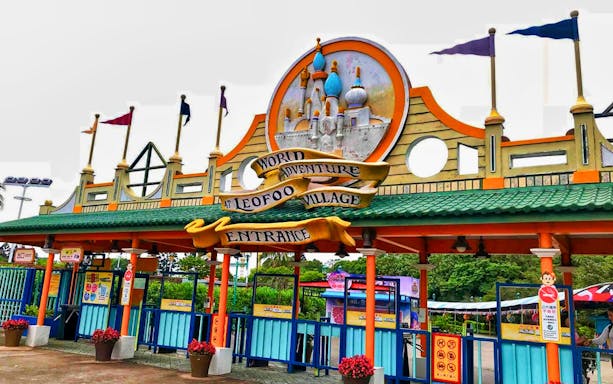 Entrance of Leofoo Village Theme Park with colorful flags and decorative sign.