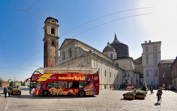 City Sightseeing Turin bus near Turin Cathedral on hop-on-hop-off tour.