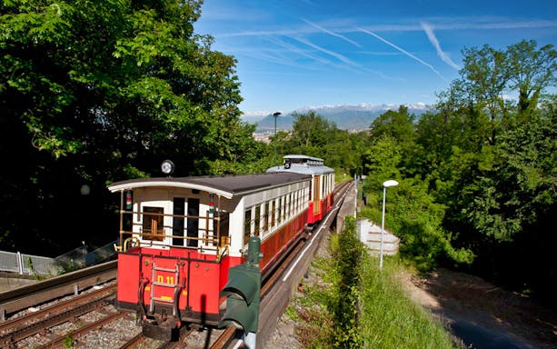 Turin tram on scenic route with Alps in background, part of City Sightseeing Turin tour.
