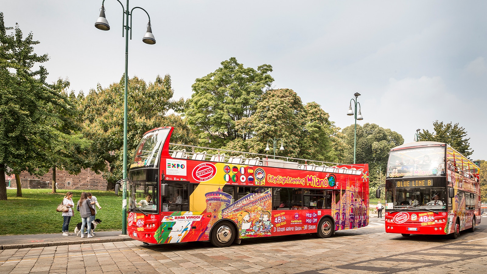 Milan hop-on-hop-off bus passing by the Duomo di Milano cathedral.