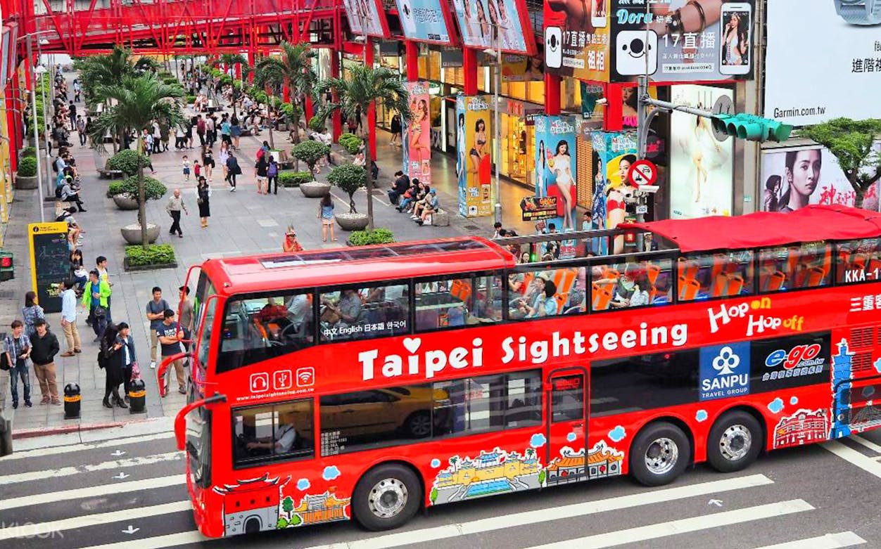 Taipei sightseeing bus passing through a busy shopping district.
