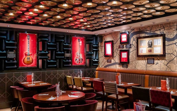 Guitars displayed in a London Hard Rock Cafe with a map-themed wall.