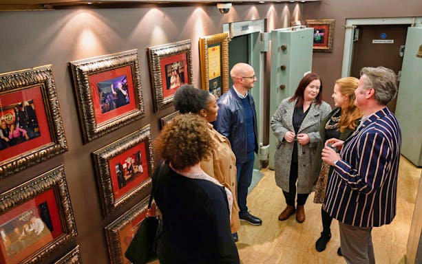Group touring Hard Rock memorabilia in London vault.
