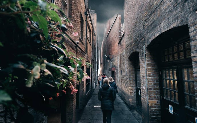 Narrow alleyway with tourists exploring a film location, part of the Magic of Film Experience tour.