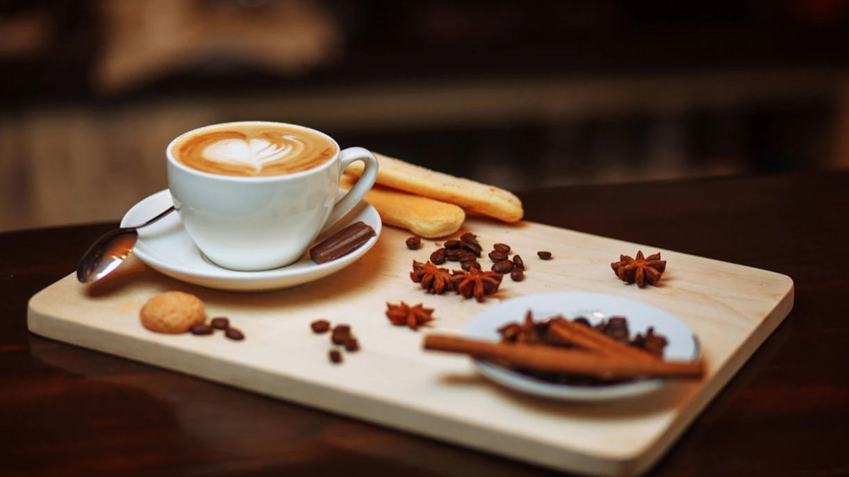 Cappuccino with latte art on a wooden board, part of a London Coffee Tour.