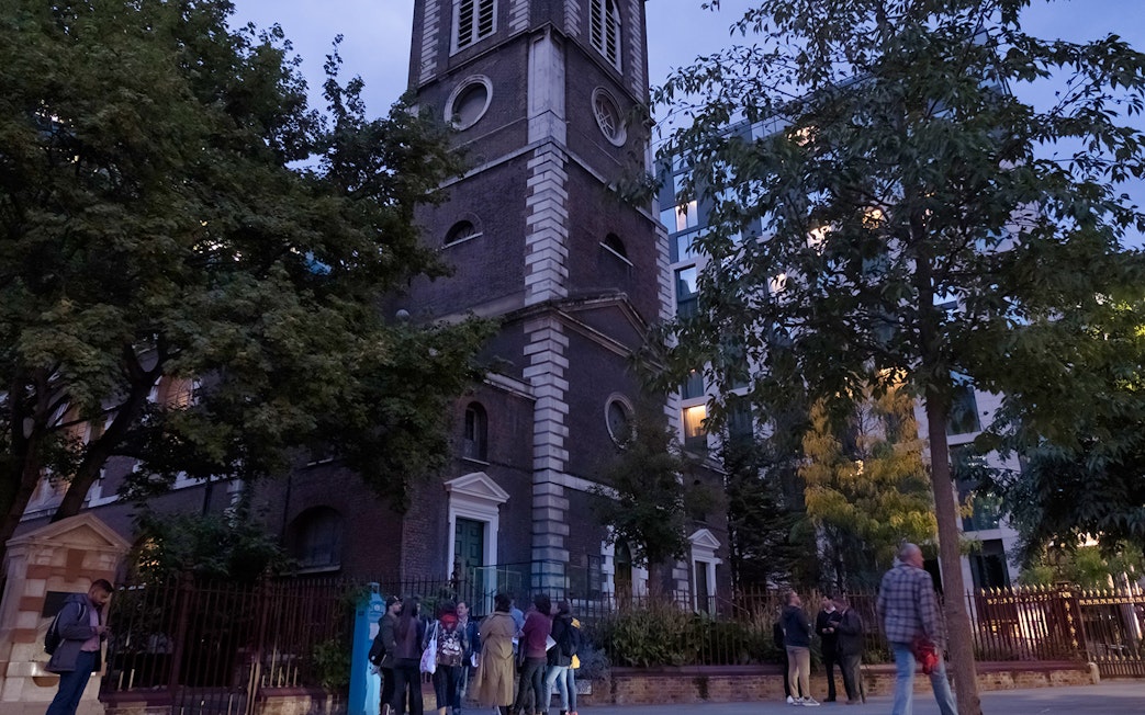 Tour group outside historic church on Jack the Ripper Tour in London.