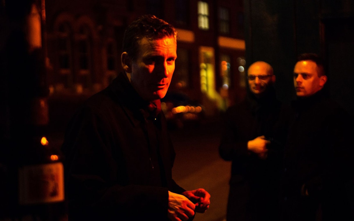 Tour guide leading Jack The Ripper & Haunted London Tour at night.